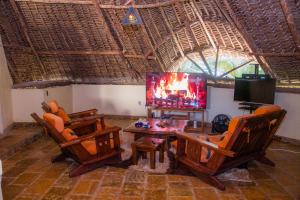 ディアニ・ビーチにあるVilla Mozillaの椅子2脚とテレビのあるリビングルーム