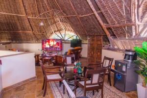 ディアニ・ビーチにあるVilla Mozillaの椅子とテレビが備わる客室です。