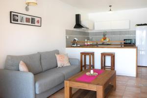 a living room with a couch and a table at SALT 6 Sur la plage de la BaieOrientale, appart 1ch in Orient Bay