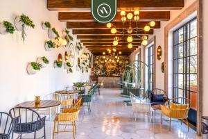 a restaurant with tables and chairs in a room with windows at 2BR Condo with Private Terrace - Ocean View - Pool in El Tule