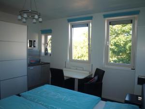 a bedroom with a bed and a desk and two windows at B&B De Domburcht in Domburg