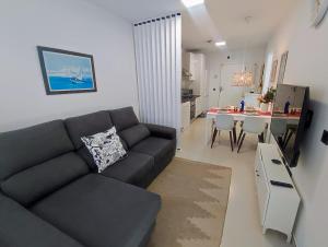 a living room with a black couch and a kitchen at Korner in Adeje