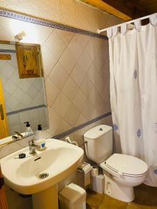 a bathroom with a white toilet and a sink at Casa Forn in Ortells