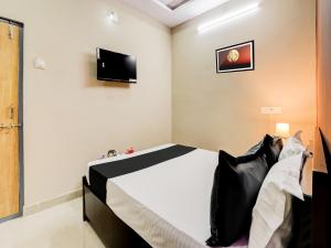 a bedroom with a bed and a tv on the wall at HOTEL O ORR RESIDENCY in Hyderabad