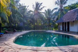 ディアニ・ビーチにあるVilla Mozillaのヤシの木が茂る家の前のスイミングプール