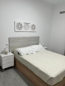 a bedroom with a large bed and a night stand at Apartamento El Rincón del Olivar III in Montoro