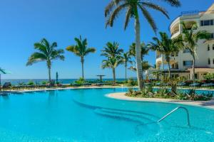 a swimming pool at a resort with palm trees at Tortuga TBB 2401 in San José del Cabo