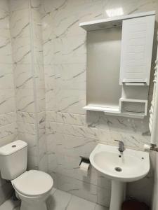 Un baño blanco con inodoro y lavabo. en Hostel Cozy House, en Sioni