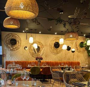 a restaurant with tables and chairs and mirrors on the wall at Hostellerie Normande in Houlgate