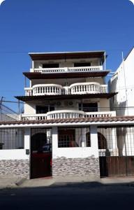 a tall white building with a red door at Casa blanca alojamientos in Manta