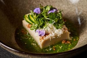 un trozo de pastel con flores encima de un plato en Arensis, en Cedro