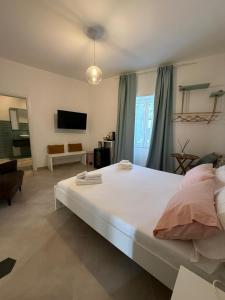 a bedroom with a large white bed and a tv at Conte Luxury Rooms in Salerno