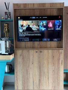 a flat screen tv sitting on top of a wooden entertainment center at Conte Luxury Rooms in Salerno +24 photos