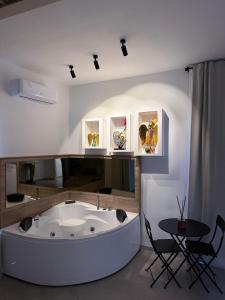 a bath tub in a room with a table and chairs at Conte Luxury Rooms in Salerno