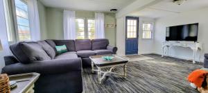 a living room with a purple couch and a tv at Welcome to Bluebird Cottage in Lakeview
