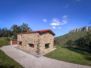 a small stone building with a mountain in the background at Cabaña Quieva 02 in Rubalcaba