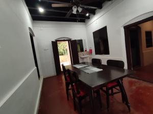 Traditional 4 Bedroom Villa - Sukun Heritage في كانور: غرفة طعام مع طاولة وكراسي ومروحة سقف