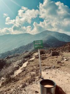 a sign on top of a mountain with a cup of coffee at Walk in the Himalayas in Pelling