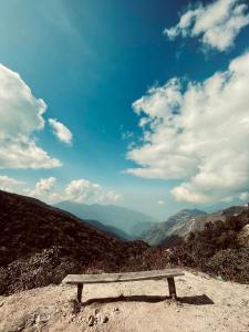 a wooden bench sitting on top of a mountain at Walk in the Himalayas in Pelling