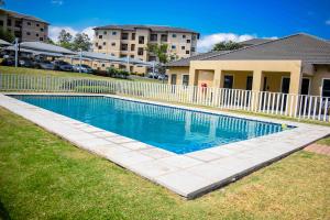 a swimming pool in front of a house at CozyHome Near Airport with pool gym and 24hour security in Boksburg
