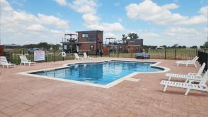 Una piscina con sillas y una casa al fondo. en Fredericksburg Retreat Hot Tub & Backyard Escape, en Fredericksburg