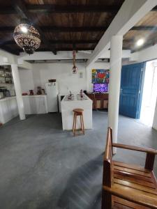 a large room with a kitchen and a table at Chalé Maison Blanche in Maracanã