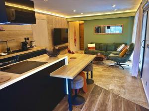 a kitchen and living room with a table and a couch at L'orée du bois - Contis - Ocean and Spa in Saint-Julien-en-Born