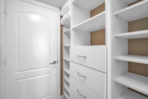 a walk in closet with white cabinets and drawers at Lux condo on 25floor in Brickell in Miami +8 photos