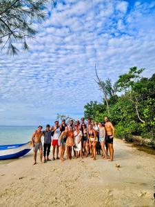 a group of people posing for a picture on the beach at Insula Hostel - The Chill Stay in Phu Quoc