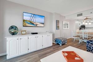 a living room with white cabinets and a dining room at Oceanfront with great beach views from all rooms & balcony, heated pool, and garage in Ormond-by-the-Sea