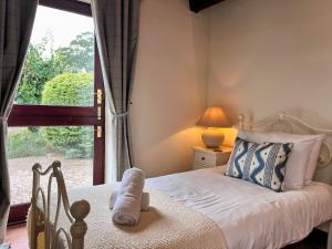 a bedroom with a bed and a large window at Stable Cottage, Oxfordshire in Oxford +24 photos