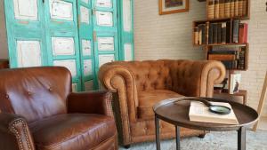 salon z 2 krzesłami, kanapą i stołem w obiekcie Plaza Santa Ponsa Boutique - Adults Only. w miejscowości Santa Ponsa