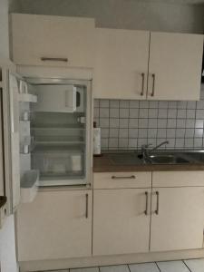 a kitchen with an open refrigerator and a sink at Thesing RE22 in Sögel