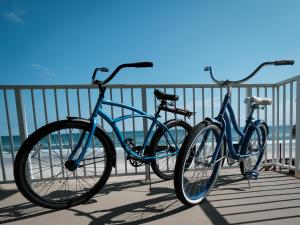 two bikes parked on a boardwalk near the beach at New listing! Direct oceanfront condo with a balcony, heated pool, and tennis court in Bottle Island