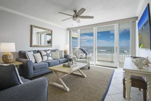 a living room with a couch and a table at New listing! Direct oceanfront condo with a balcony, heated pool, and tennis court in Bottle Island