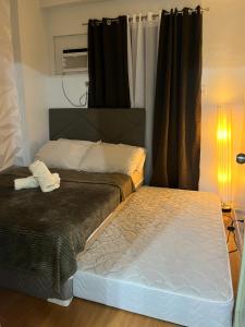 ein Schlafzimmer mit zwei Betten und einer Lampe in der Unterkunft Camella Northpoint in Davao City