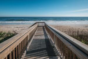a wooden walkway to the beach with the ocean at New listing! Direct oceanfront with private balcony, pool, and hot tub in Bottle Island