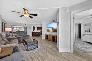 a living room with a couch and a ceiling fan at New listing! Direct oceanfront with private balcony, pool, and hot tub in Bottle Island