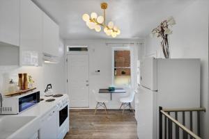 a kitchen with white appliances and a white refrigerator at The Twisty Nest on 17th in Philadelphia