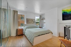 Un dormitorio blanco con una cama y una ventana. en The Twisty Nest on 17th, en Filadelfia