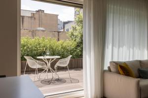 a living room with a balcony with a table and chairs at The Central City - Luxury Serviced Residence in Luxembourg
