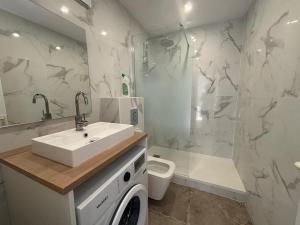 Un baño con lavabo, inodoro y ducha. en New Apartment Hotel Palais des Congrès Porte Maillot 31, en Levallois-Perret