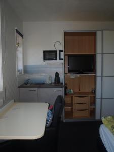 um pequeno quarto com uma cozinha e uma secretária com uma televisão em B&B De Domburcht em Domburg