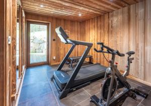 einen Fitnessraum mit Laufband und Fahrrad in einem Zimmer in der Unterkunft Chalet 1907, pleine vue lac in Gérardmer