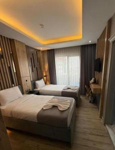 a hotel room with two beds and a television at Hotel And free shuttle in Istanbul +3 photos