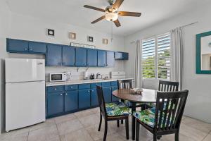 a kitchen with blue cabinets and a table and chairs at Town Treasure - Walkable - King Bed - AC in Christiansted