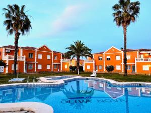 a large swimming pool with palm trees in the background at Oliva Nova Equestrian Apartment Next to MET Showground in Oliva