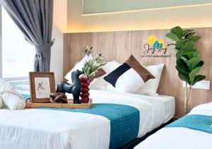 a bedroom with two beds and a table with flowers at Amber Cove l Luxury Suites 2BR l 6-9pax l GamesRoom l City Centre l Jonker St l Encore l Playground by Jay Stay in Melaka