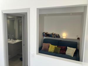 een badkamer met een blauwe bank en een wastafel bij Studio Luberon in Pertuis