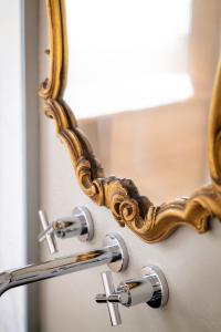 a mirror on a bathroom sink with a faucet at Dimora Moncher in Montignoso